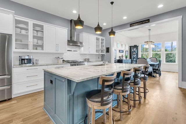 kitchen featuring a center island with sink, white cabinetry, sink, and appliances with stainless steel finishes