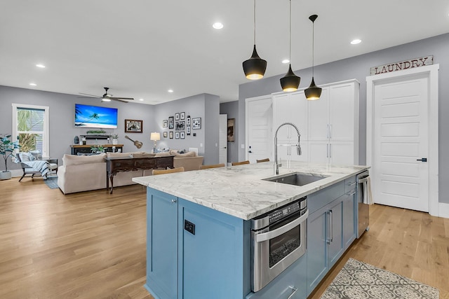 kitchen featuring pendant lighting, light hardwood / wood-style floors, sink, and appliances with stainless steel finishes