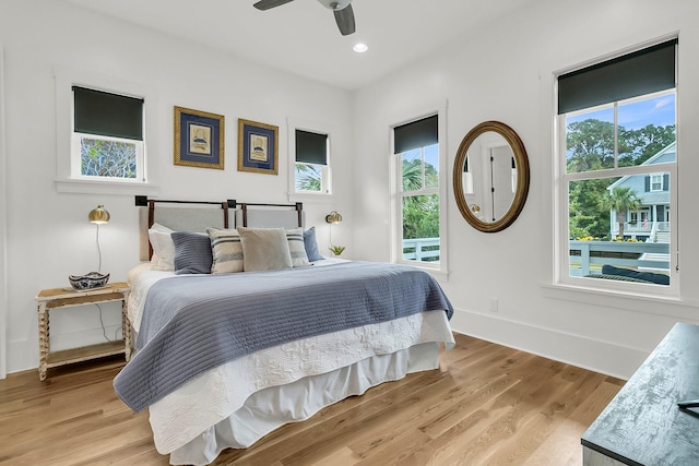 bedroom featuring multiple windows, ceiling fan, and light hardwood / wood-style floors