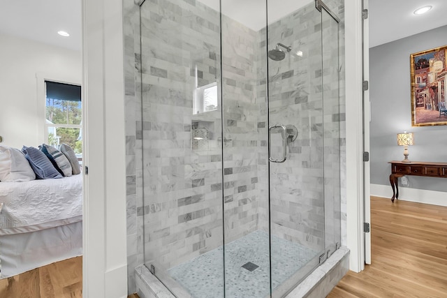 bathroom with hardwood / wood-style flooring and an enclosed shower