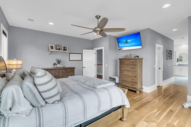 bedroom with light wood-type flooring, ensuite bathroom, and ceiling fan