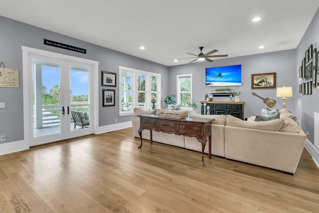 living room featuring ceiling fan, light wood-type flooring, and french doors