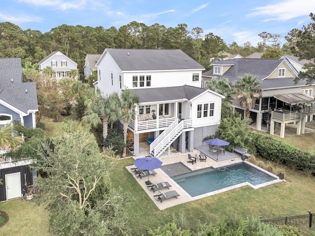 rear view of house with a patio and a lawn