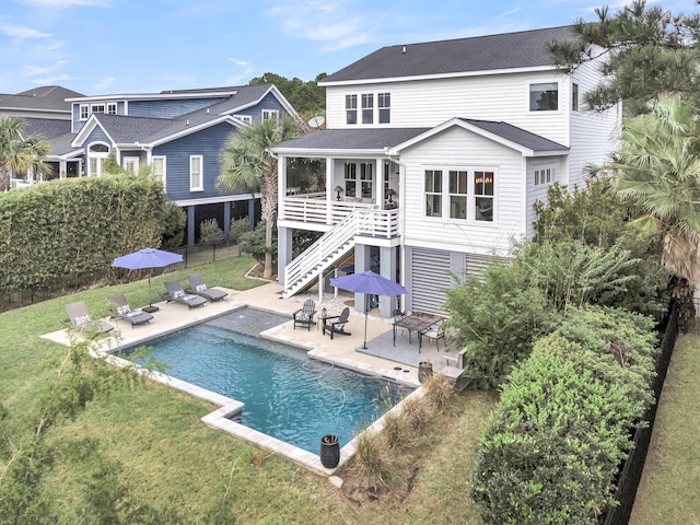 back of house with a lawn and a patio