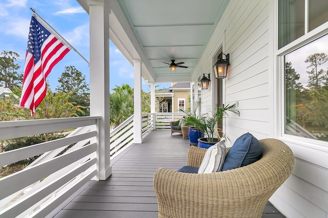 wooden deck featuring covered porch and ceiling fan