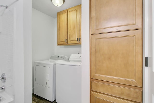 clothes washing area featuring separate washer and dryer and cabinet space