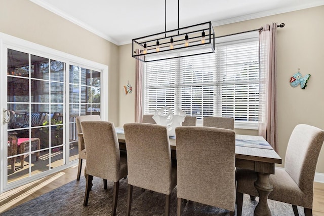 dining space with ornamental molding and wood finished floors