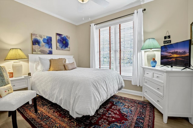 bedroom featuring light wood-style floors, baseboards, ornamental molding, and a ceiling fan