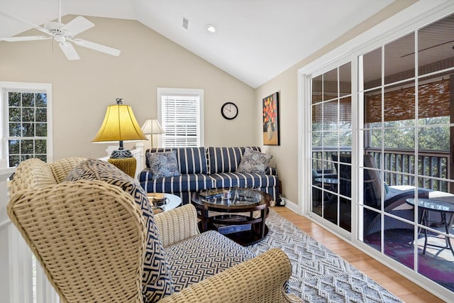 living room featuring ceiling fan, visible vents, vaulted ceiling, and wood finished floors