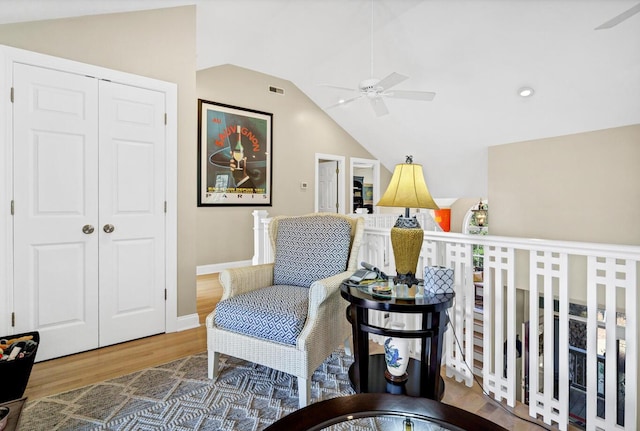 sitting room featuring a ceiling fan, vaulted ceiling, baseboards, and wood finished floors