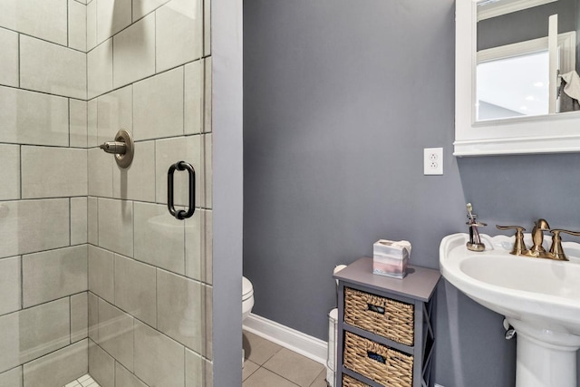 full bath with a stall shower, baseboards, tile patterned flooring, and toilet