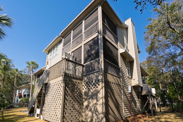 view of home's exterior with a chimney, fence, and stairway