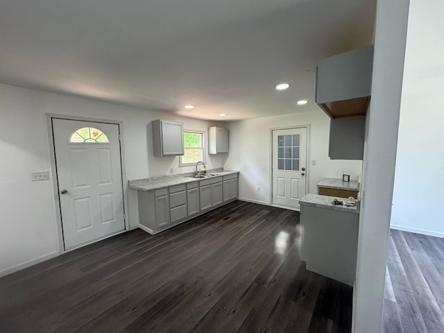 kitchen with gray cabinetry, a sink, recessed lighting, dark wood-style flooring, and light countertops