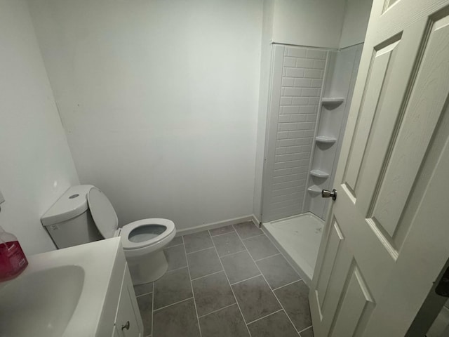 bathroom featuring toilet, vanity, a shower stall, and tile patterned flooring