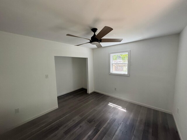 unfurnished bedroom with baseboards, dark wood-style flooring, and a closet