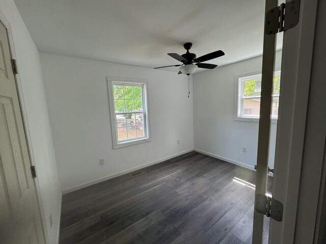 unfurnished bedroom featuring dark wood-style flooring, baseboards, and ceiling fan
