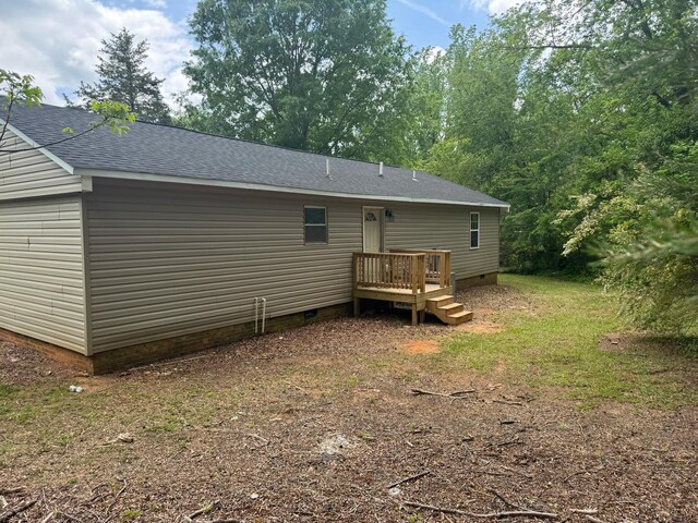 rear view of house featuring crawl space, a shingled roof, and a wooden deck