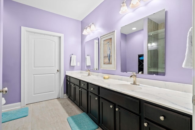 bathroom with double vanity, baseboards, and a sink