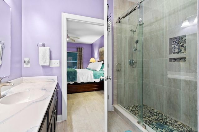 bathroom with ceiling fan, ensuite bath, vanity, and a shower stall