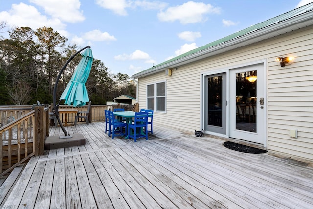 wooden deck with outdoor dining space and fence