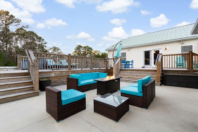 view of patio / terrace with a wooden deck and an outdoor living space with a fire pit