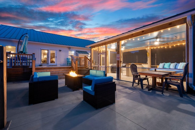 view of patio / terrace with outdoor dining space and an outdoor living space with a fire pit