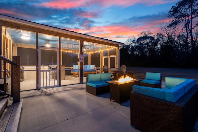 patio terrace at dusk with a sunroom and an outdoor living space with a fire pit