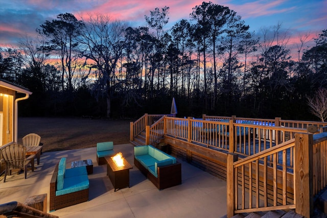 patio terrace at dusk featuring an outdoor living space with a fire pit