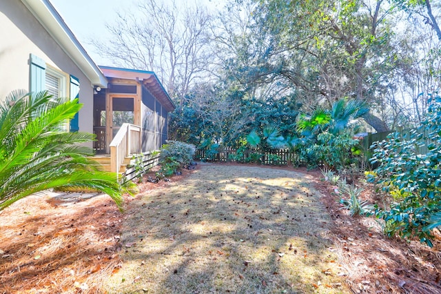 view of yard featuring a sunroom and a fenced backyard