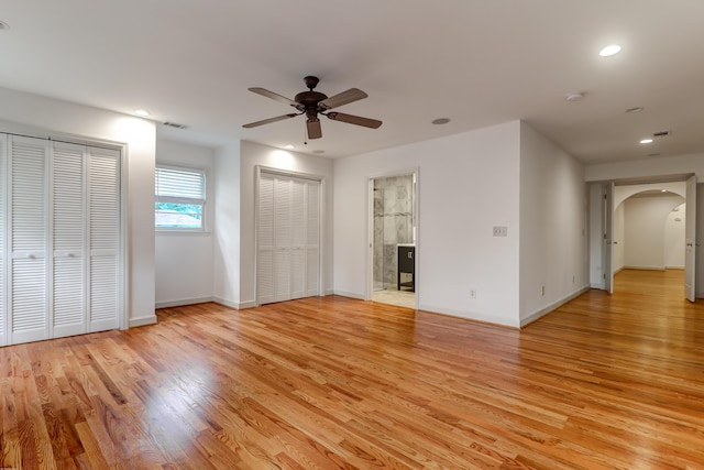 interior space with arched walkways, recessed lighting, visible vents, a ceiling fan, and light wood-style floors