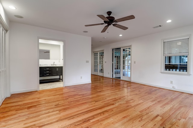 interior space featuring light wood-style floors, recessed lighting, and a sink