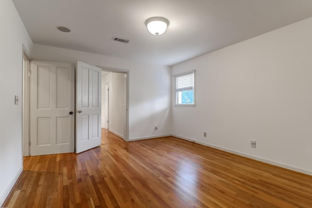 unfurnished bedroom with light wood-type flooring, baseboards, and visible vents