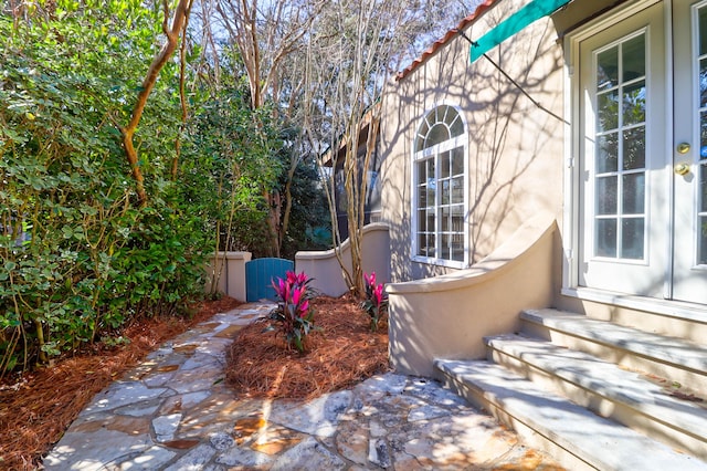 view of side of home featuring entry steps and a gate