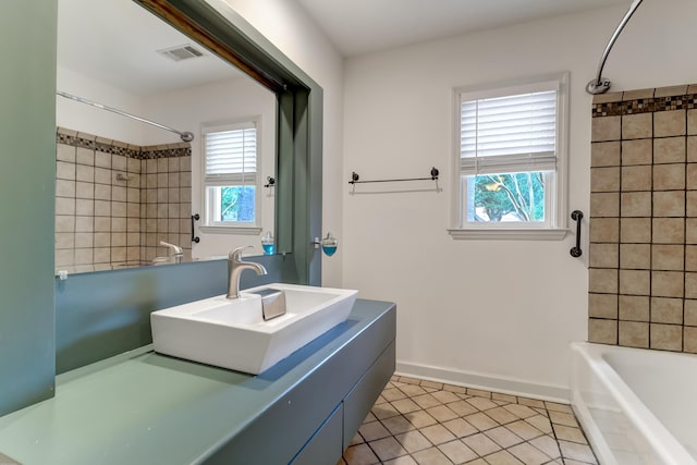 full bathroom featuring shower / bath combination, visible vents, a sink, tile patterned flooring, and baseboards