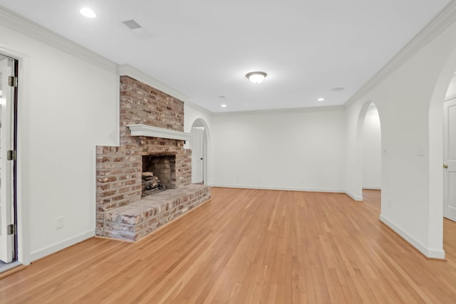 unfurnished living room featuring arched walkways, a fireplace, and crown molding