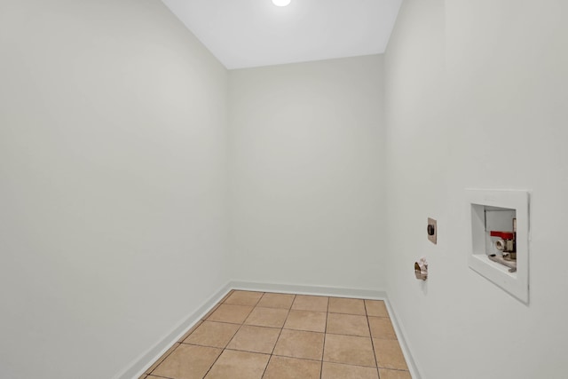 clothes washing area featuring hookup for a washing machine, hookup for an electric dryer, light tile patterned flooring, laundry area, and baseboards