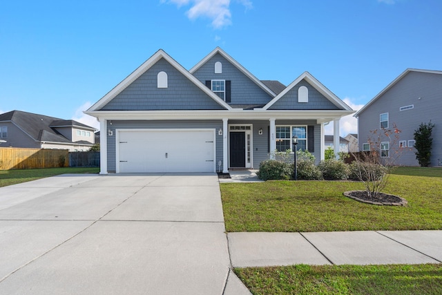 view of front of house featuring a front lawn, a garage, and covered porch