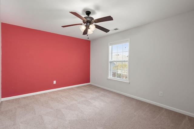 spare room featuring ceiling fan and light colored carpet