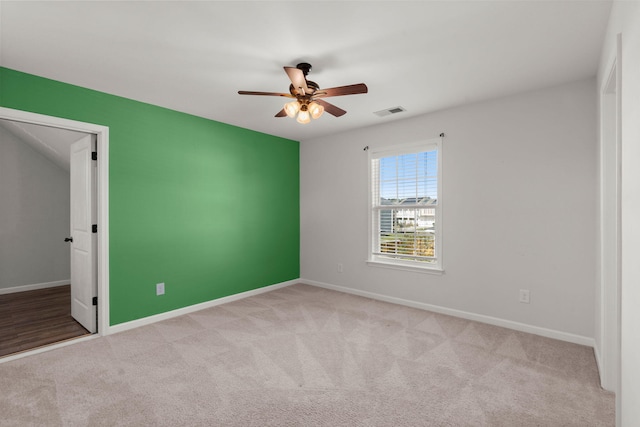 spare room featuring ceiling fan and light colored carpet