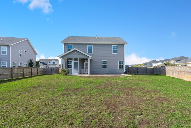 rear view of house with a lawn, a patio, and a sunroom