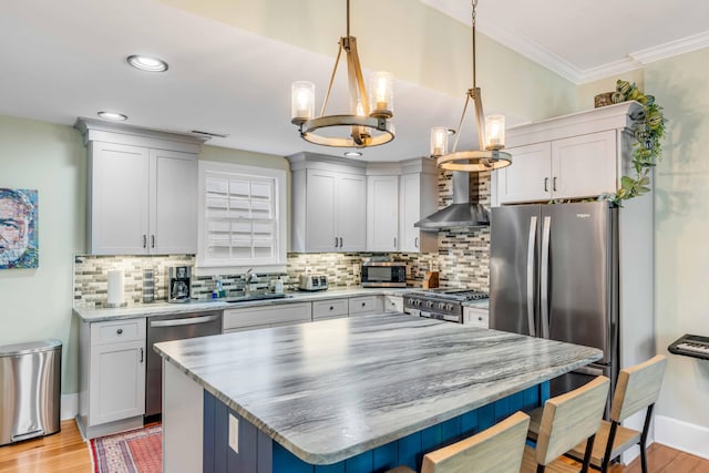 kitchen featuring a center island, hanging light fixtures, light hardwood / wood-style floors, stainless steel appliances, and a chandelier