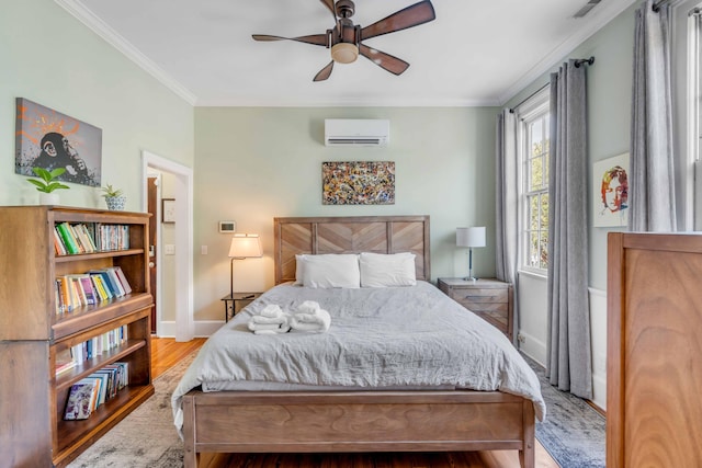 bedroom featuring ceiling fan, an AC wall unit, crown molding, and light hardwood / wood-style flooring