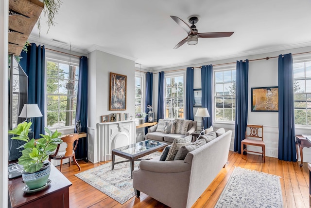 living room with ceiling fan, light wood-type flooring, and ornamental molding