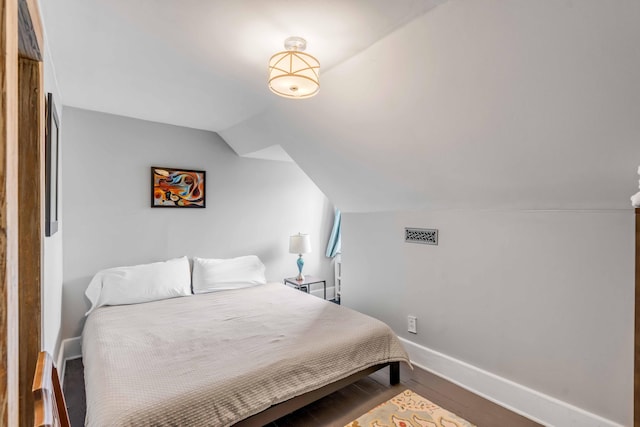 bedroom with hardwood / wood-style flooring and vaulted ceiling