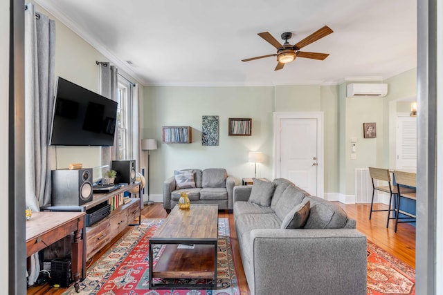 living room with ceiling fan, wood-type flooring, ornamental molding, and a wall mounted AC