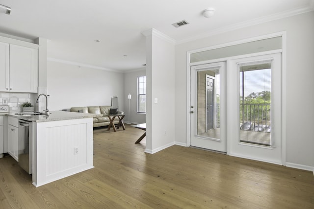 kitchen featuring visible vents, white cabinetry, open floor plan, stainless steel dishwasher, and light wood-type flooring