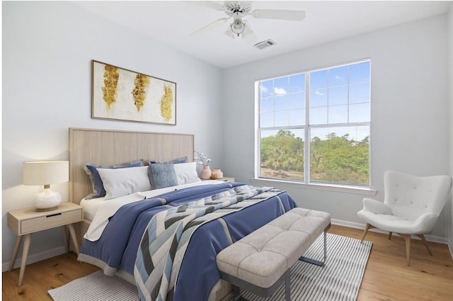 bedroom with light wood-type flooring, visible vents, ceiling fan, and baseboards