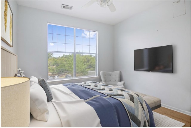 bedroom featuring baseboards, wood finished floors, visible vents, and a ceiling fan