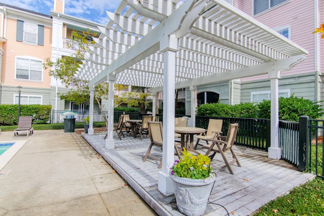 view of patio with outdoor dining space, fence, and a pergola