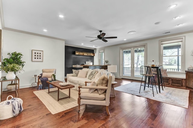 living area featuring a ceiling fan, dark wood-style floors, and ornamental molding